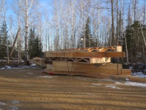 roof trusses in a pile, custom lake home, huisman concepts