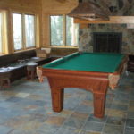 basement pool table room with fireplace