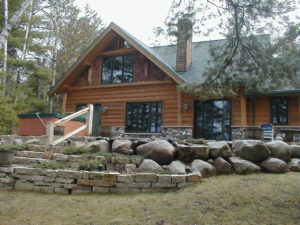 Exterior from lake, stone landscaping