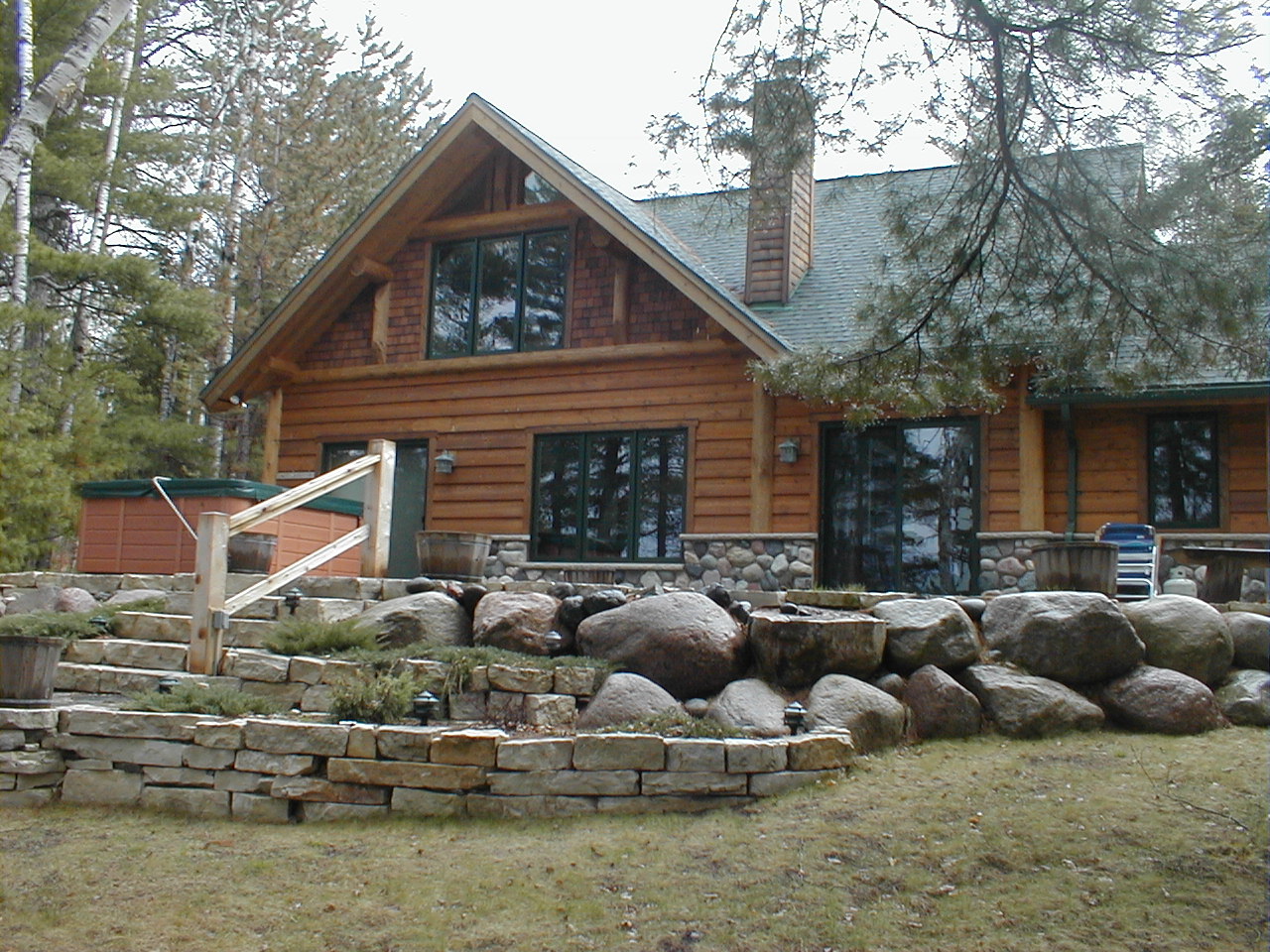 Exterior from lake, stone landscaping