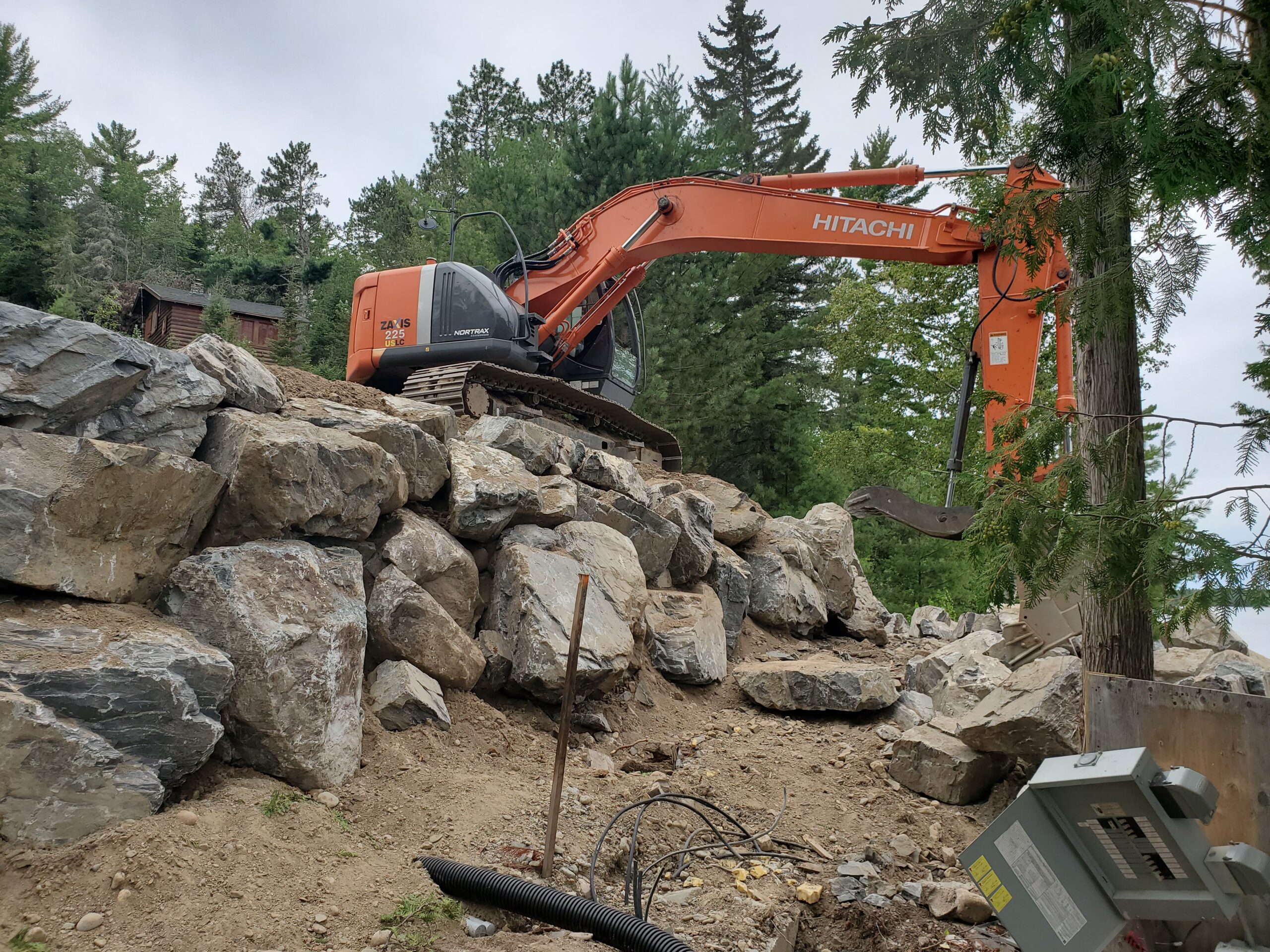 Retaining wall under way Retaining wall boulders, custom home by Huisman Concepts, Ely MN Retaining wall under way Retaining wall boulders, custom home by Huisman Concepts, Ely MN