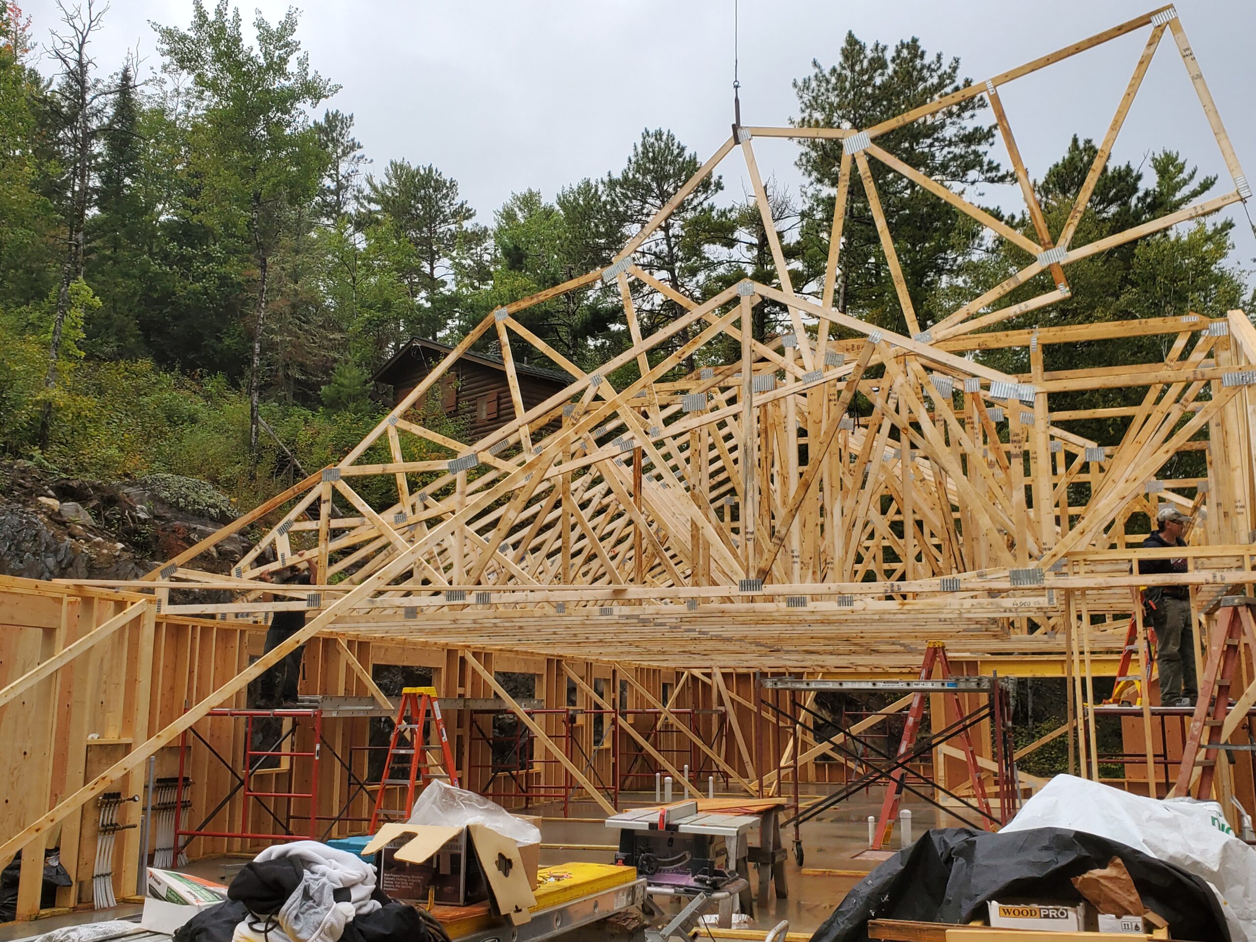 Trusses going up Crane setting trusses, custom home by Huisman Concepts
